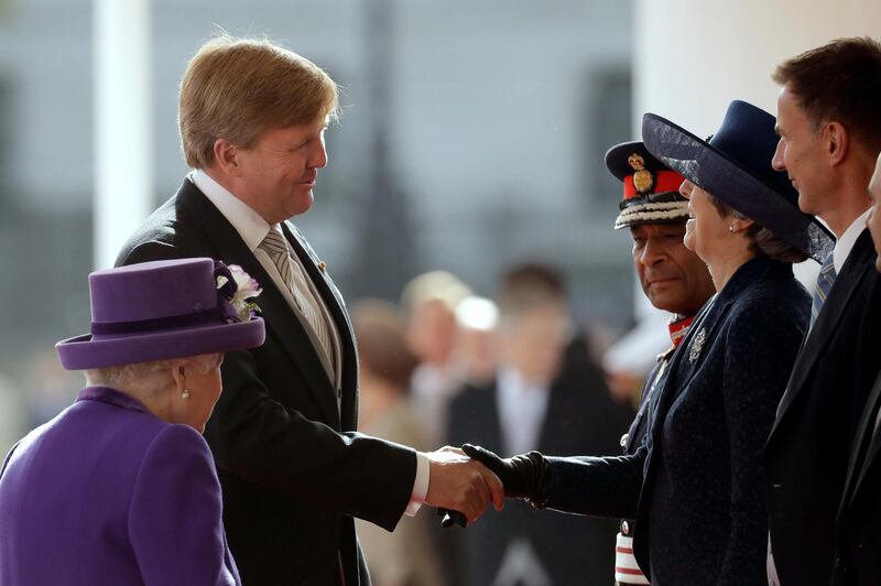 British Prime Minister Theresa May greets Dutch King Willem-Alexander of the Netherlands as Queen Elizabeth II looks on during a Ceremonial Welcome on Horse Guards Parade. The last State Visit from the Netherlands was by Queen Beatrix and Prince Claus in 1982. Matt Dunham / AFP