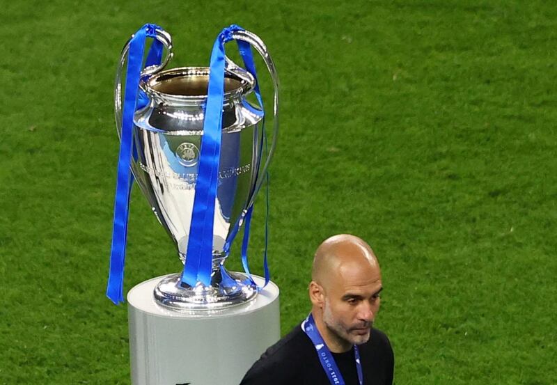 Pep Guardiola looks dejected as he walks past the Champions League trophy. Reuters
