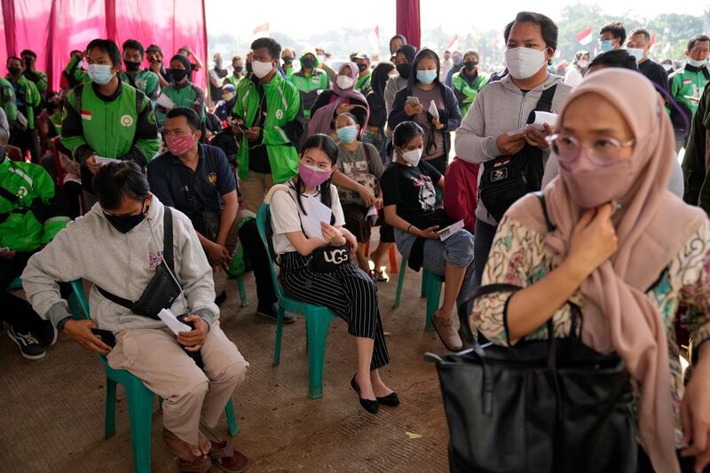 People queue for vaccination against the coronavirus in Depok on the outskirts of Jakarta, Indonesia. The world's fourth most populous country has reported a surge in infections in recent weeks, adding urgency to the government's plan to inoculate a million people each day by next month. AP