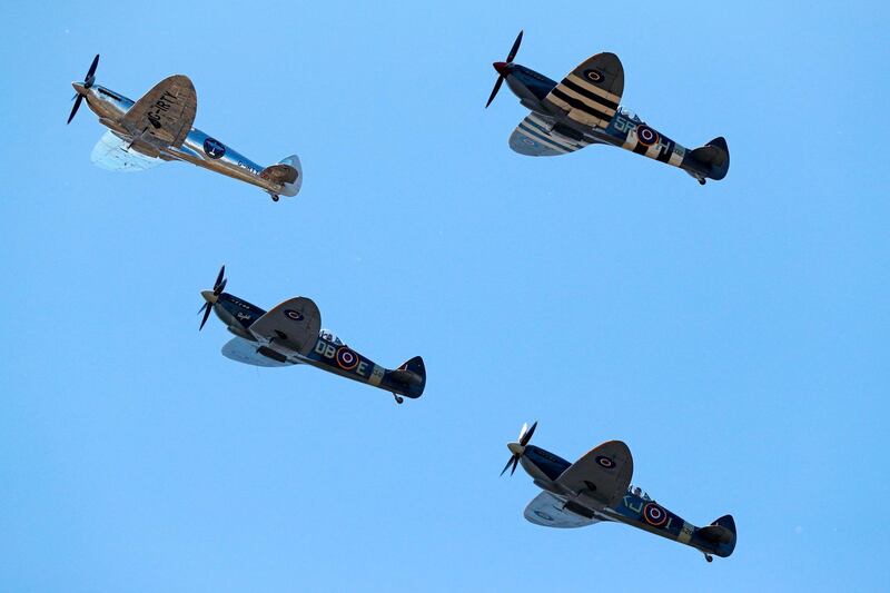 British aviator Matt Jones (L) flies over the airfield, escorted by three other Spitfires based at Goodwood. Adrian Dennis / AFP