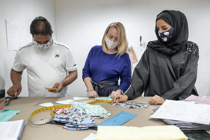 DUBAI, UNITED ARAB EMIRATES. 04 AUGUST 2020. UAE Space Molly and Me Kids Clothing, which has sold almost 30,000 face masks since April. Masks being produced at Mixari Ladies Tailoring. Tailor Siraj Ahmed cuts patterns along with Kate Burford and Buthaina Rais at Mixari Ladies Tailoring. (Photo: Antonie Robertson/The National) Journalist: Gillian Duncan. Section: National.