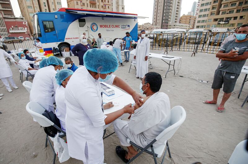 A man receives a dose of a COVID-19 coronavirus vaccine during a mass vaccination campaign in the Bneid Al-Gar district of Kuwait City on October 11, 2021.  - The Ministry of Health announced launching a COVID-19 vaccination campaign across several areas in Kuwait on October 11.  (Photo by YASSER AL-ZAYYAT  /  AFP)