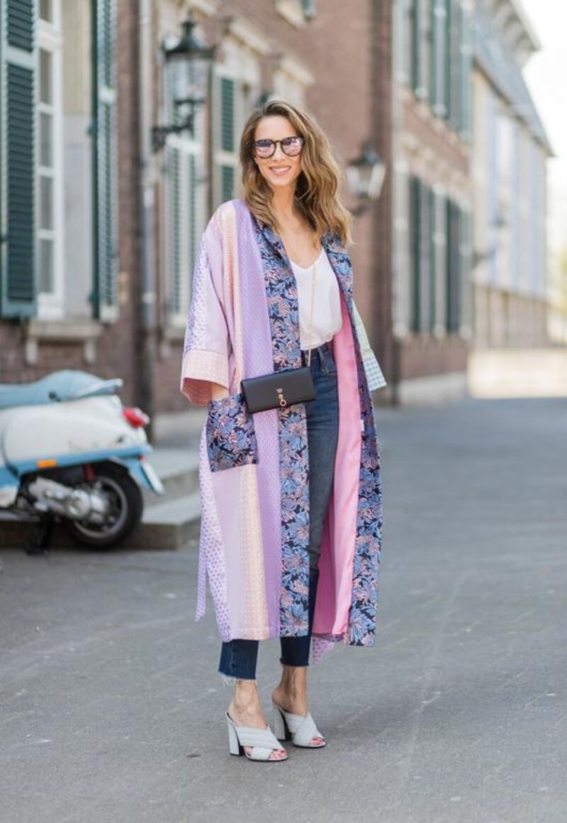 Model and fashion blogger Alexandra Lapp wearing a printed kimono / panel robe from Natasha Zinko, slim fit high waist Jeans from Rag & Bone, Mules by Gucci with open-toe-silhouette in glittery silver grey, white silk tank top from Jadicted, colourful mirrored sunglasses from Les Specs, black leather ring detail continental purse bag from Fendi. Christian Vierig / Getty Images