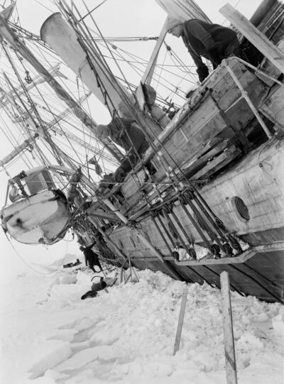 Ernest Shackleton leaning over the side of the Endurance, which is trapped in ice. Photo: Royal Geographic Society 