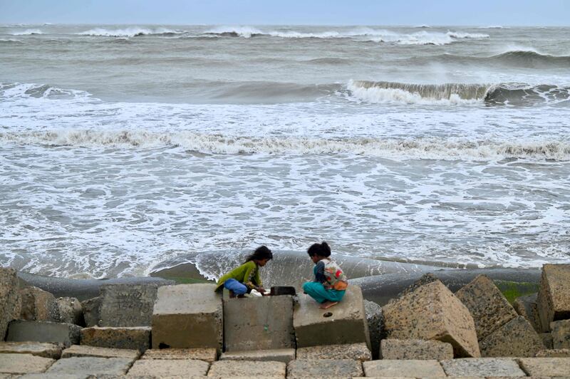 Children play near choppy waters on Shahpori island, Bangladesh, hours before Cyclone Mocha made landfall. AFP