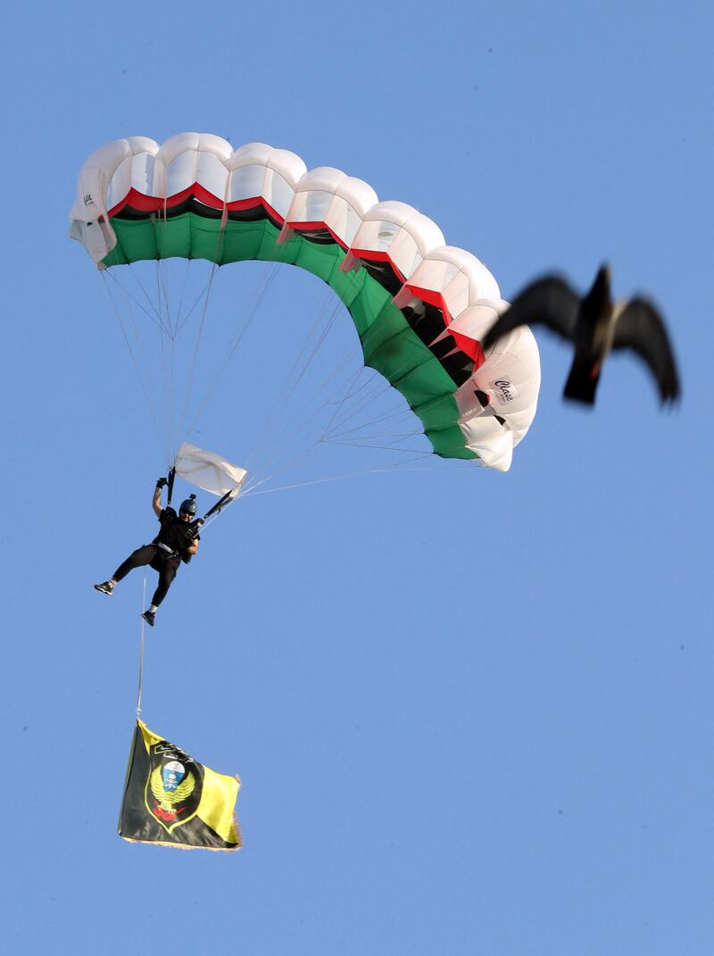 A parachutist lands during the parade to mark the army anniversary.