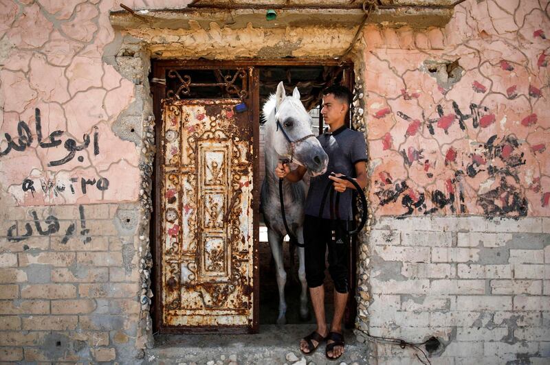 A Palestinian takes his horse out of a house used as a stable in Gaza City. AFP