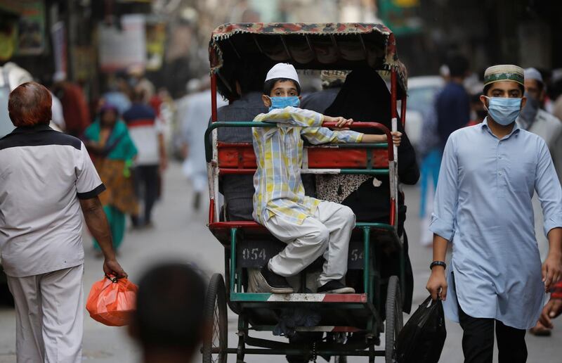 A Muslim boy wearing a protective face mask travels in a cycle rickshaw on the eve of the holy fasting month in the old quarters of Delhi, India, on April 24, 2020. Reuters