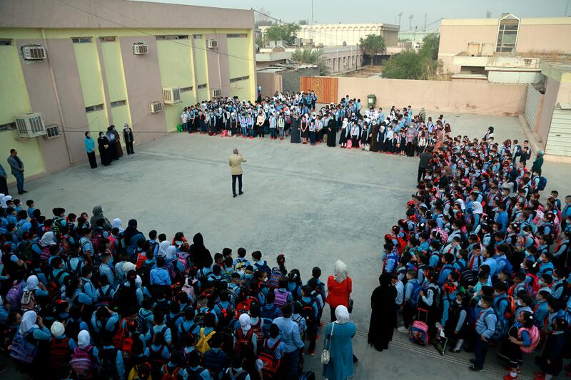 School pupils in masks gather in the playground at the beginning of the school year in Baghdad, Iraq. Children returned to classrooms on Monday for the first time in 18 months – a stoppage caused by the coronavirus pandemic. AP