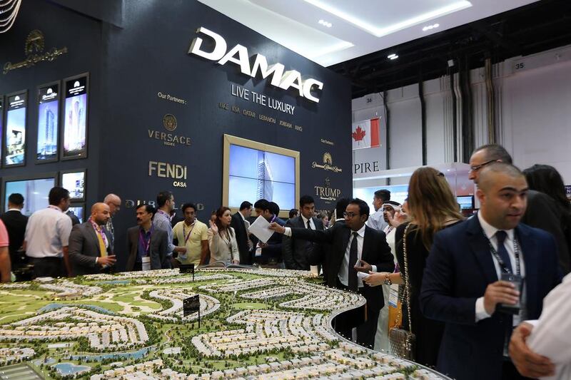 Visitors at the Damac stand at Cityscape Global in Dubai look at a model of a development to be built. Pawan Singh / The National