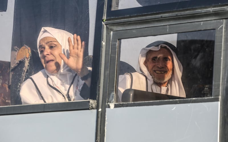 A Palestinian Muslim pilgrim waves to her relatives as she sits in a bus at the Rafah border crossing between the Gaza Strip and Egypt.  AFP