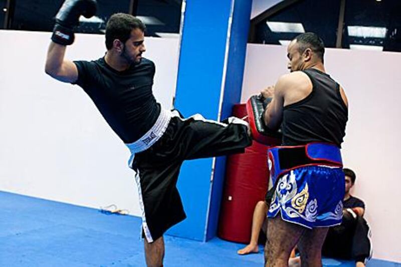 Ahmed Abdul Raheem Ahmed Al Hosani, left, trains with his coach Juma Ben Jama at World Gym in Abu Dhabi. The Emirati, who is deaf and cannot speak, aims to represent the UAE at the Olympics.