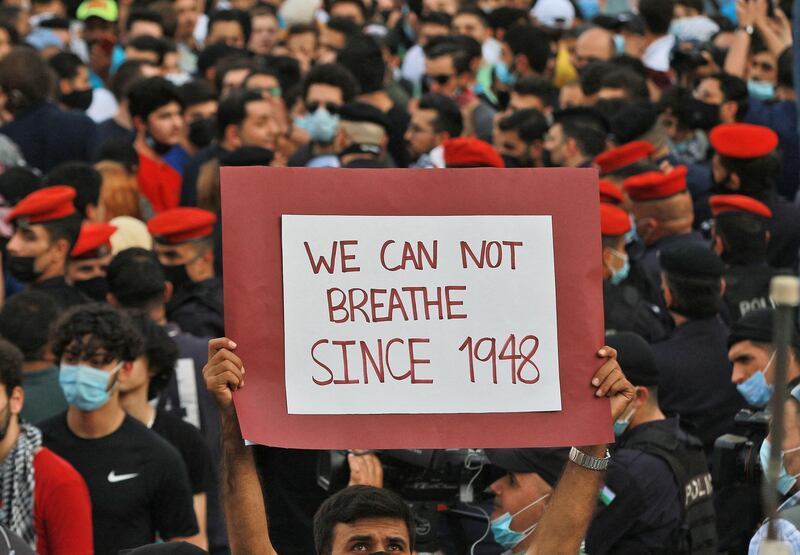 A man holds a sign during a protest to express solidarity with the Palestinian people near the Israeli embassy in Jordan's capital Amman. AFP