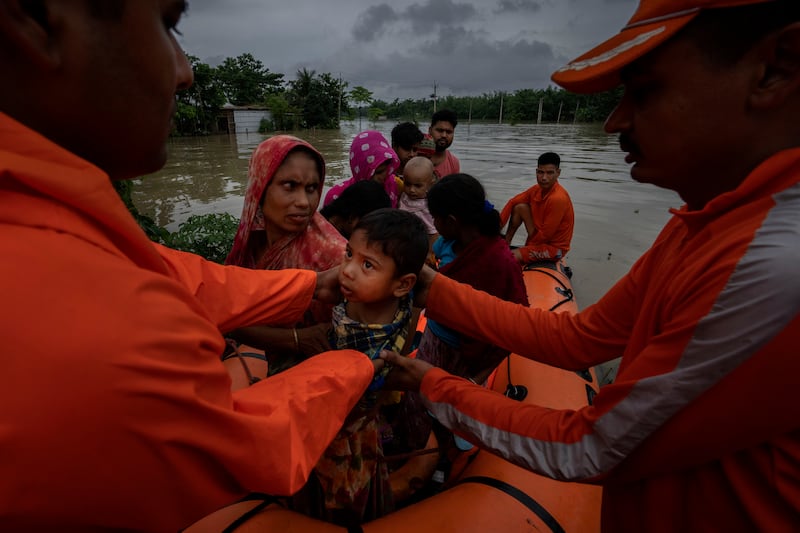 Rescuers evacuate villagers from the flooded Korora village, west of Guwahati, in India's Assam state. AP 