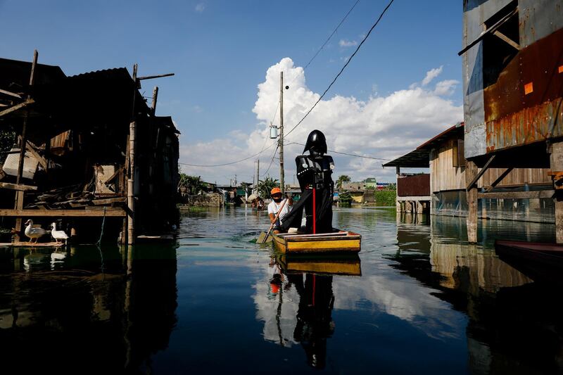 A village officer dressed as the Star Wars character Darth Vader rides a small boat to deliver relief goods to residents in the flooded Artex Compound in Malabon, Metro Manila, Philippines, May 4, 2020. REUTERS/Eloisa Lopez