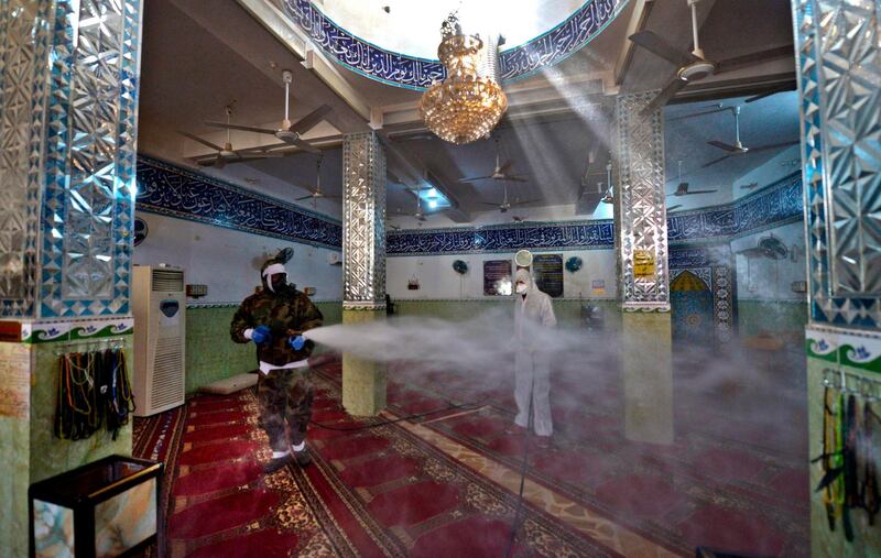 Members of the Iraqi civil defence disinfect a mosque in Najaf linked to a recent confirmed case of coronavirus.  AFP
