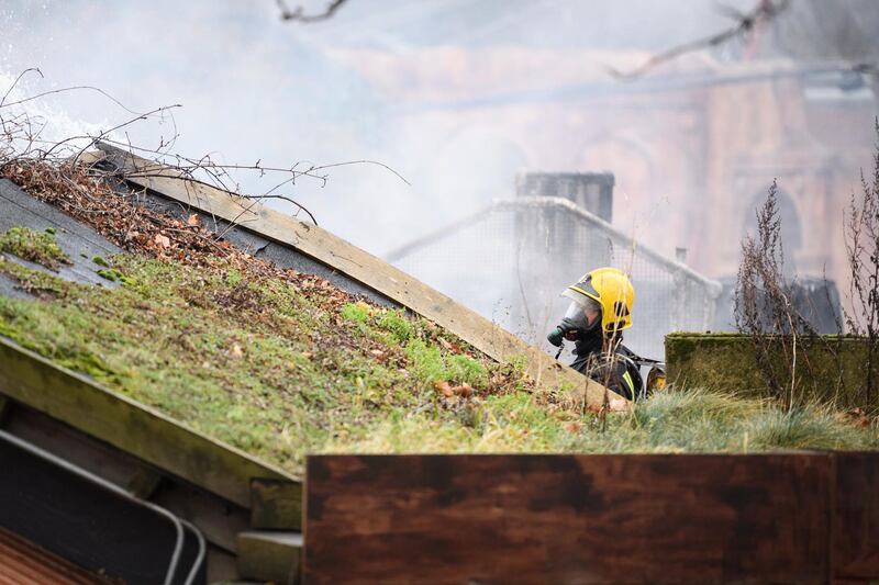 A firefighter checks the area after a fire destroyed a number of buildings at London Zoo. Leon Neal / Getty Images.