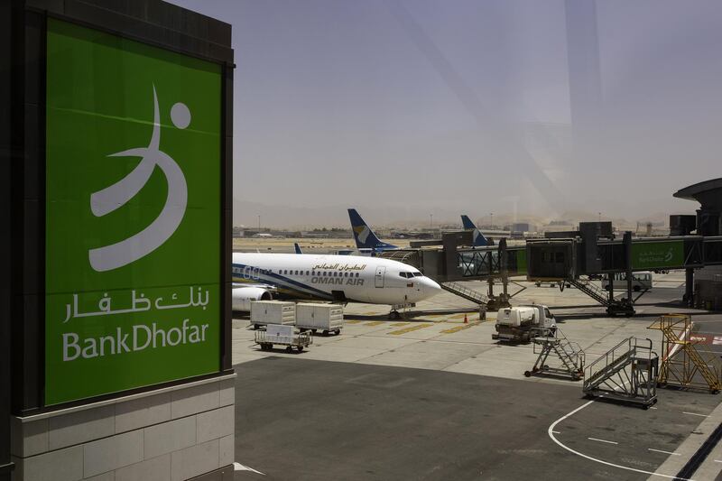 An advertisement for Bank Dhofar SAOG sits on display in the passenger terminal at Muscat International Airport in Muscat, Oman, on Monday, May 7, 2018. Being the Switzerland of the Gulf served the country well over the decades, helping the sultanate survive, thrive and make it a key conduit for trade and diplomacy in the turbulent Middle East. Photographer: Christopher Pike/Bloomberg