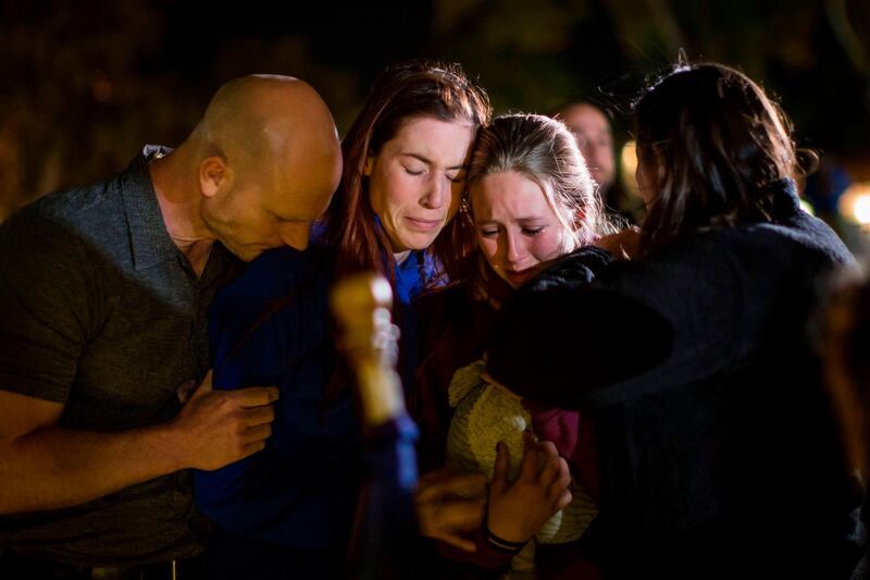 People hug and cry during a vigil to pay tribute to the victims. AFP