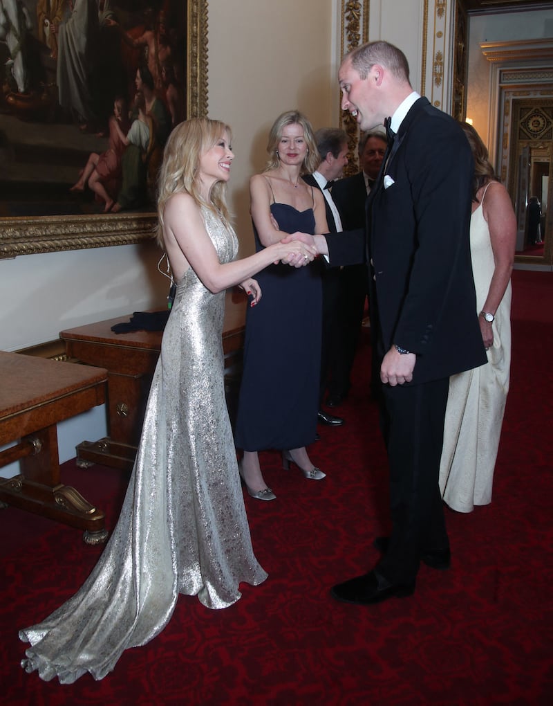 Prince William meets Australian-British singer Kylie Minogue, left, as Lady Helen Taylor looks on, during a reception for the Royal Marsden NHS Foundation Trust at Buckingham Palace, London on June 14, 2018. AFP