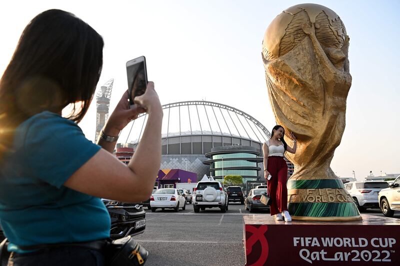 A woman poses in front of the Khalifa Stadium in Doha ahead of the Qatar 2022 FIFA World Cup football tournament. AFP