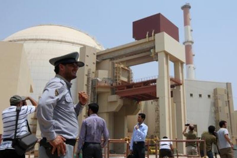(FILES) -- An Iranian security man stands next to journalists outside the reactor building at the Russian-built Bushehr nuclear power plant in southern Iran on August 21, 2010. The Stuxnet computer worm has infected 30,000 computers in Iran but has failed to "cause serious damage," Iranian officials were quoted as saying on September 26, 2010. A German computer security researcher suspected Stuxnet's target was the Bushehr nuclear facility in Iran, where unspecified problems have been blamed for getting the facility fully operational. AFP PHOTO/ATTA KENARE