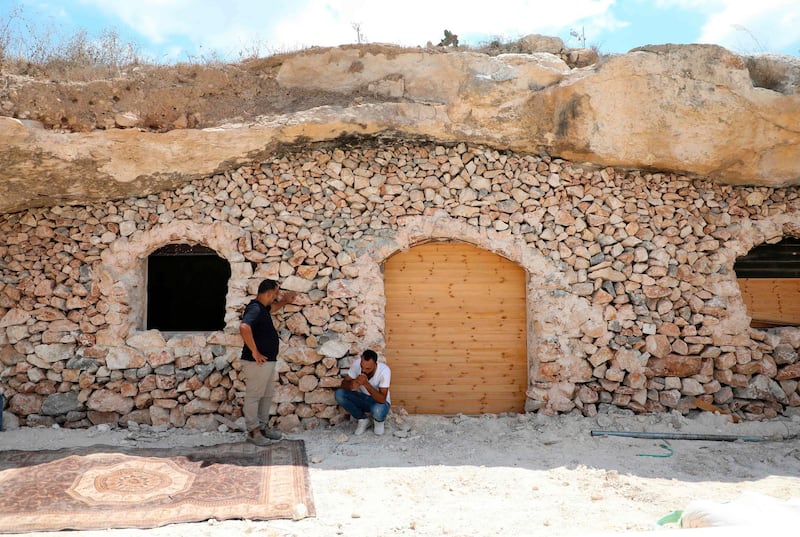 Ahmed Amarneh and a neighbour chat outside his home. The 30-year-old civil engineer said he chose to live in a cave because Israeli authorities refused to give him permission to build a house.
AFP
