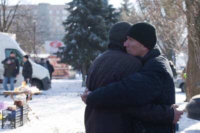 Friends comfort each other at the site of the fatal strike in Donetsk on Sunday. AFP