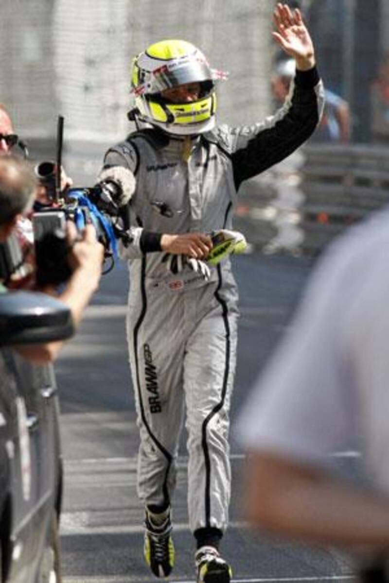 Jenson Button waves to fans as he trots towards the winners' podium after winning last year's Monaco Grand Prix.