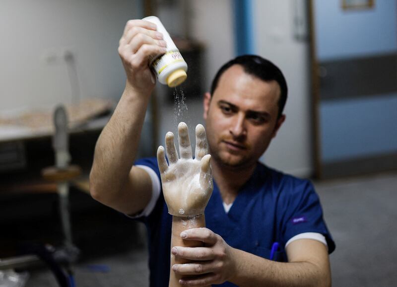 A Palestinian technician prepares the myoelectric arm, which has allowed Mr Hamda, who lost his right hand in 2007 when unexploded ordnance detonated, to play with his two children, eat, drink and do home repairs.