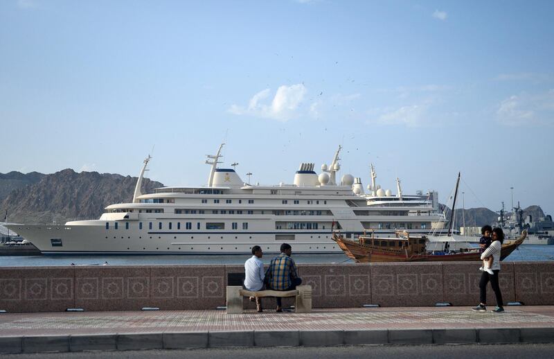 People walk on the waterfront near a yacht for Oman's Sultan Haitham bin Tarik Al Saidat in Muscat on February 21, 2020. (Photo by ANDREW CABALLERO-REYNOLDS / AFP)