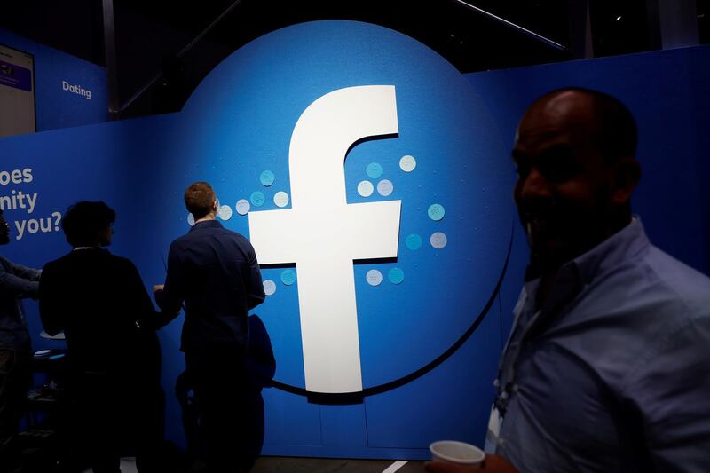 FILE PHOTO: Attendees walk past a Facebook logo during Facebook Inc's F8 developers conference in San Jose, California, U.S., April 30, 2019.  REUTERS/Stephen Lam/File Photo  GLOBAL BUSINESS WEEK AHEAD