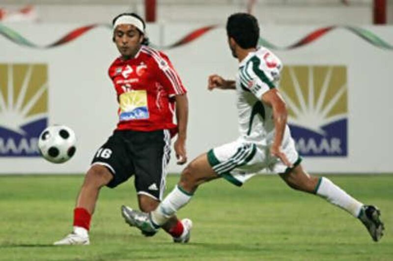 Al Ahli's Hassan Ali, left, plays the ball past an Al Khaleej player during his side's 3-0 victory.