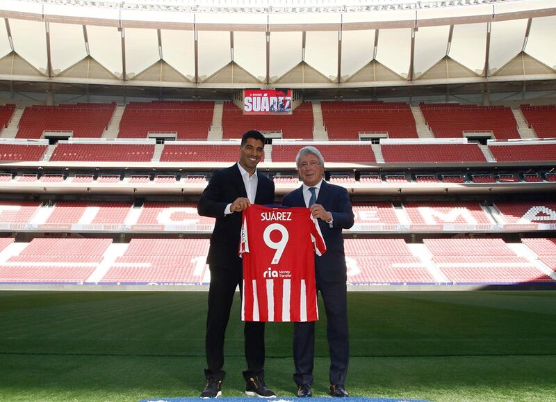 Uruguayan forward Luis Suarez poses with Atletico Madrid's president Enrique Cerezo. AFP