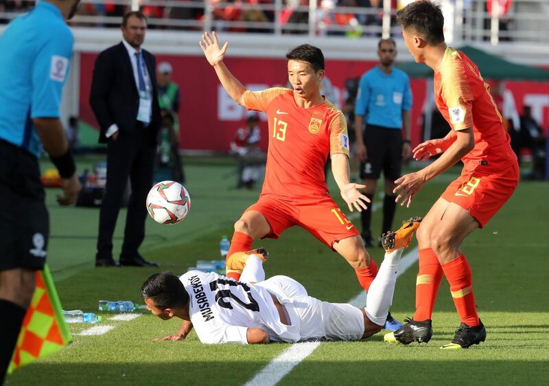 China's midfielder Zhongguo Chi and forward Xiao Zhi fight for the ball with Kyrgyzstan's midfielder Farhat Musabekov. AFP