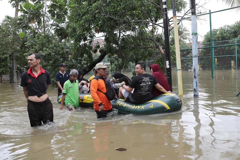 Rescuers evacuate residents from their flooded neighbourhood in Tanggerang.  AP