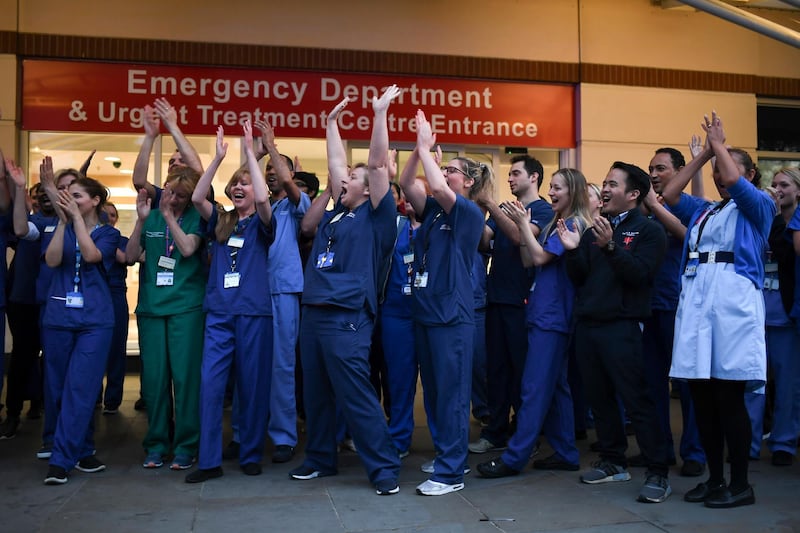 NHS staff applaud outside the Chelsea and Westminster Hospital in London during the weekly "Clap for our Carers" in April 2020. The applause took place across Britain every Thursday at 8pm to show appreciation for healthcare workers, emergency services, and all those helping people with coronavirus and keeping the country functioning while most people stayed at home in the lockdown. AP Photo