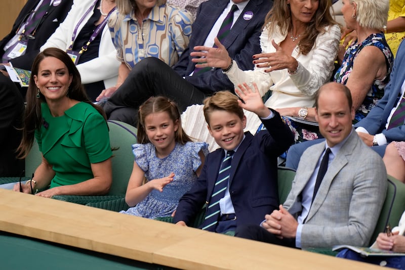 Prince George waves as he watches the tennis with his family. AP