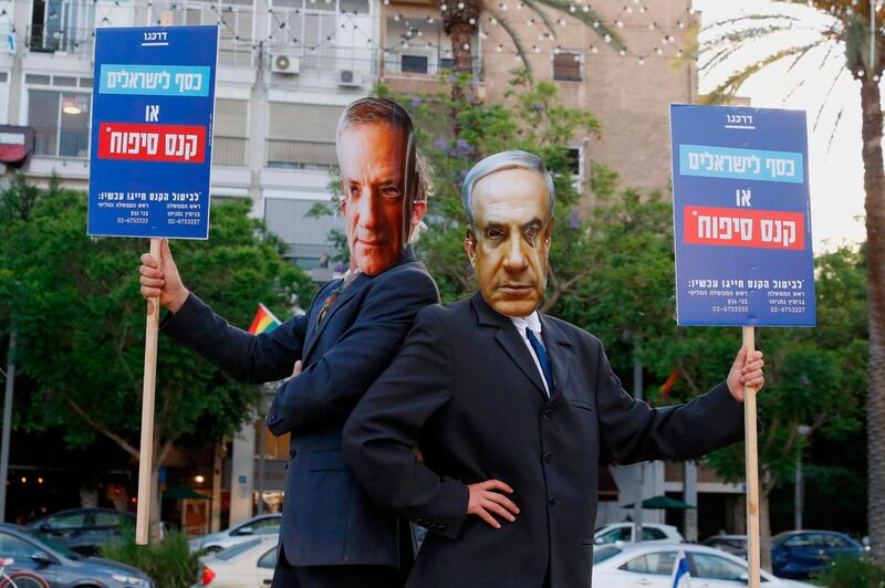 Protesters, wearing masks of Israel's Prime Minister Benjamin Netanyahu and his coalition partner Defence Minister Benny Gantz, take part in a demonstration in Tel Aviv's Rabin Square to denounce Israel's plan to annex parts of the occupied West Bank. AFP