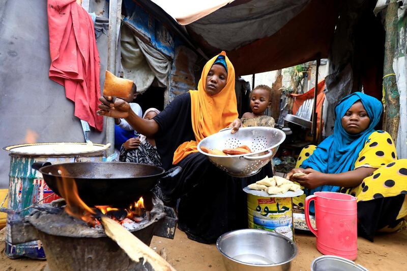 An internally displaced Somali woman and her children prepare their Iftar meal during the month of Ramadan at the Shabelle makeshift camp in Hodan district of Mogadishu, Somalia April 24, 2020. REUTERS/Feisal Omar
