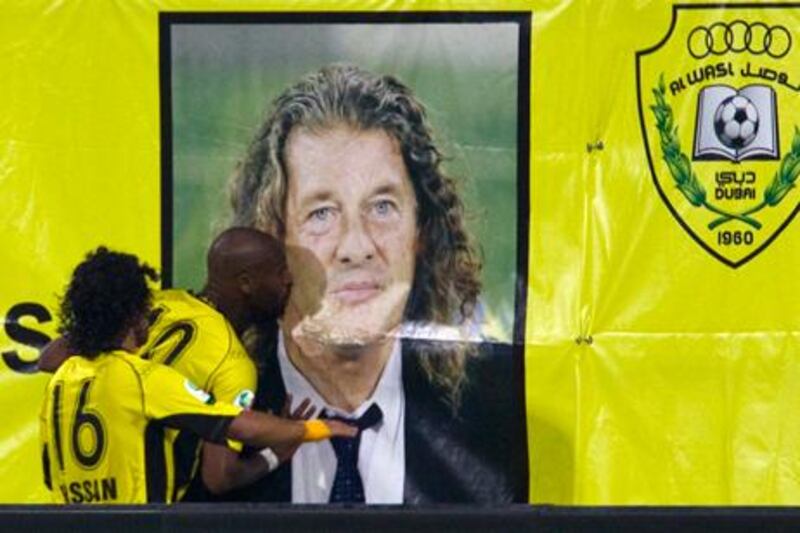 Al Wasl's Mahmoud Abdeiraek kisses a banner wishing former head coach Bruno Metsu well after celebrating his goal against Al Dhafra