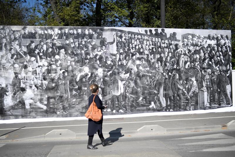 epa05915599 A woman walks past a giant fresco of the inhabitants of the Clichy-Montfermeil suburb during its inauguration, in Clichy-Montfermeil, east of Paris, France, 19 April 2017. The artwork entitled 'Chronicles of Clichy-Montfermeil' was co-realised by French photographer JR and French artist Ladj Ly.  EPA/STEPHANE DE SAKUTIN / POOL MAXPPP OUT - RESTRICTED TO EDITORIAL USE - MANDATORY MENTION OF THE ARTIST UPON PUBLICATION - TO ILLUSTRATE THE EVENT AS SPECIFIED IN THE CAPTION  EDITORIAL USE ONLY