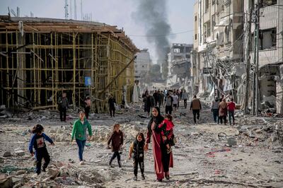 Palestinians walk over rubble in Gaza city after a four-day truce deal led to a pause in Israeli air strikes. AFP