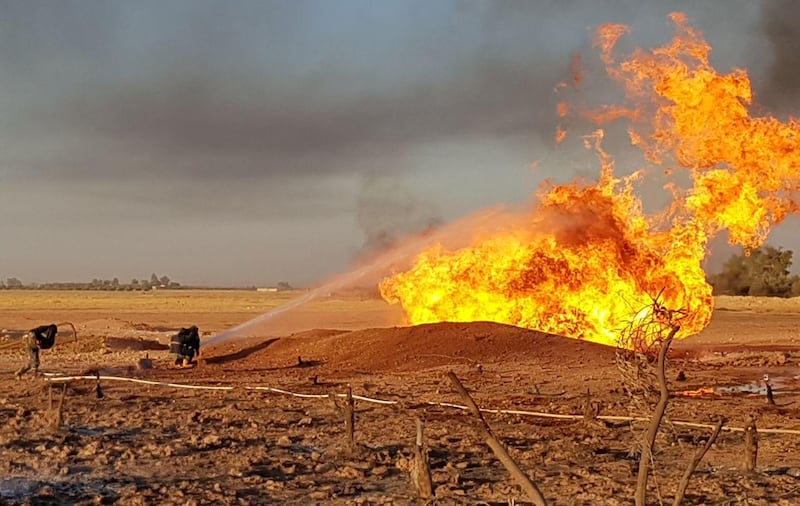 A firefighter sprays water on the fire that resulted from an explosion on the Arab Gas Pipeline between the towns of Ad Dumayr and Adra, northwest of the capital of Damascus, Syria in this handout released by SANA on August 24, 2020. SANA/Handout via REUTERS ATTENTION EDITORS - THIS IMAGE WAS PROVIDED BY A THIRD PARTY. REUTERS IS UNABLE TO INDEPENDENTLY VERIFY THIS IMAGE.