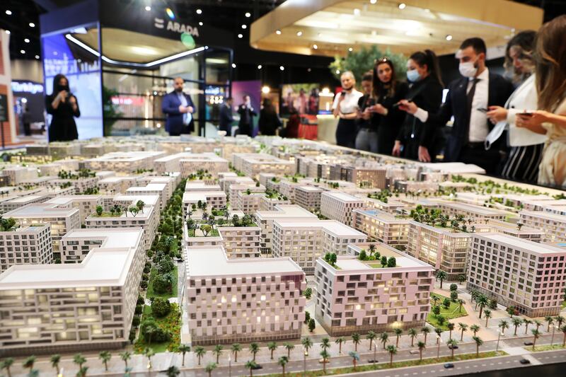 Visitors at the Arada stand look at the model of Aljada development area in Sharjah at Cityscape Global in Dubai on November 9, 2021. Pawan Singh / The National