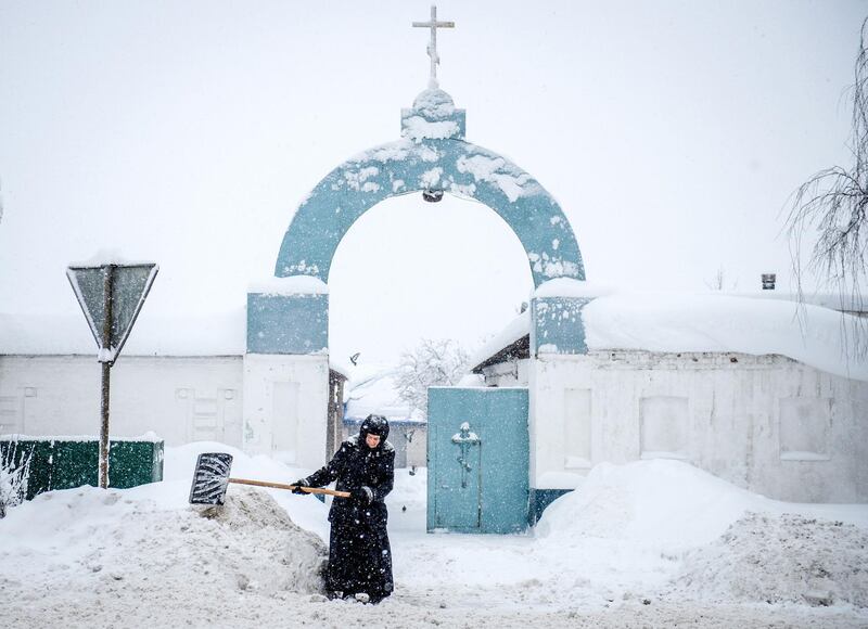 A nun removes snow during a snowfall in front of the gate of the Bogoslovsky nunnery in the village of Bogoslovo in Vladimirsky region some 190 km outside Moscow. Konstantin Chalabov / AFP Photo