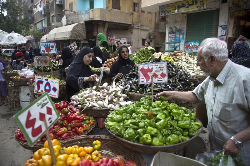 Egypt has been wrestling with a currency crisis that economists blame on an overvalued pound. Pictured, Egyptians buy vegetables from a traditional market in old Cairo. AFP