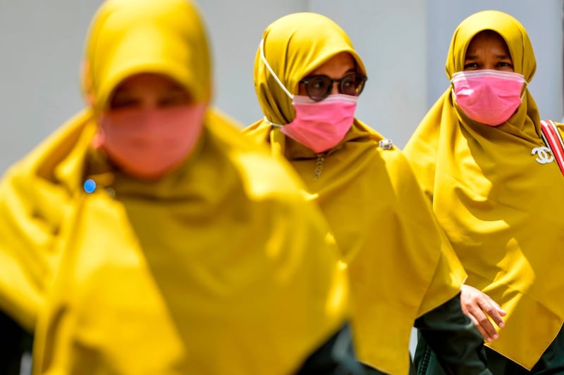 Women wearing face masks walk in a public area in Banda Aceh. Indonesia. AFP