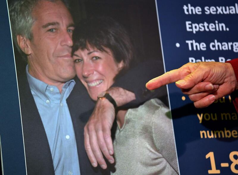 (FILES) In this file photo taken on July 2, 2020 a photo of Ghislaine Maxwell and Jeffrey Epstein is seen as acting US Attorney for the Southern District of New York, Audrey Strauss, announces charges against Maxwell during a press conference in New York City. US President Donald Trump said on July 21, 2020 that he had not been following closely Ghislaine Maxwell's arrest on sex trafficking minors for Jeffrey Epstein but that he wished her well. / AFP / Johannes EISELE
