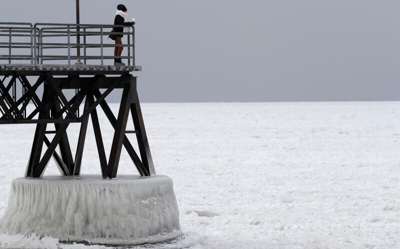 Michele King, 26, looks out over frozen Lake Erie, Wednesday, Jan. 3, 2018, in Cleveland. Dangerously cold temperatures have gripped wide swaths of the U.S. from Texas to New England. (AP Photo/Tony Dejak)